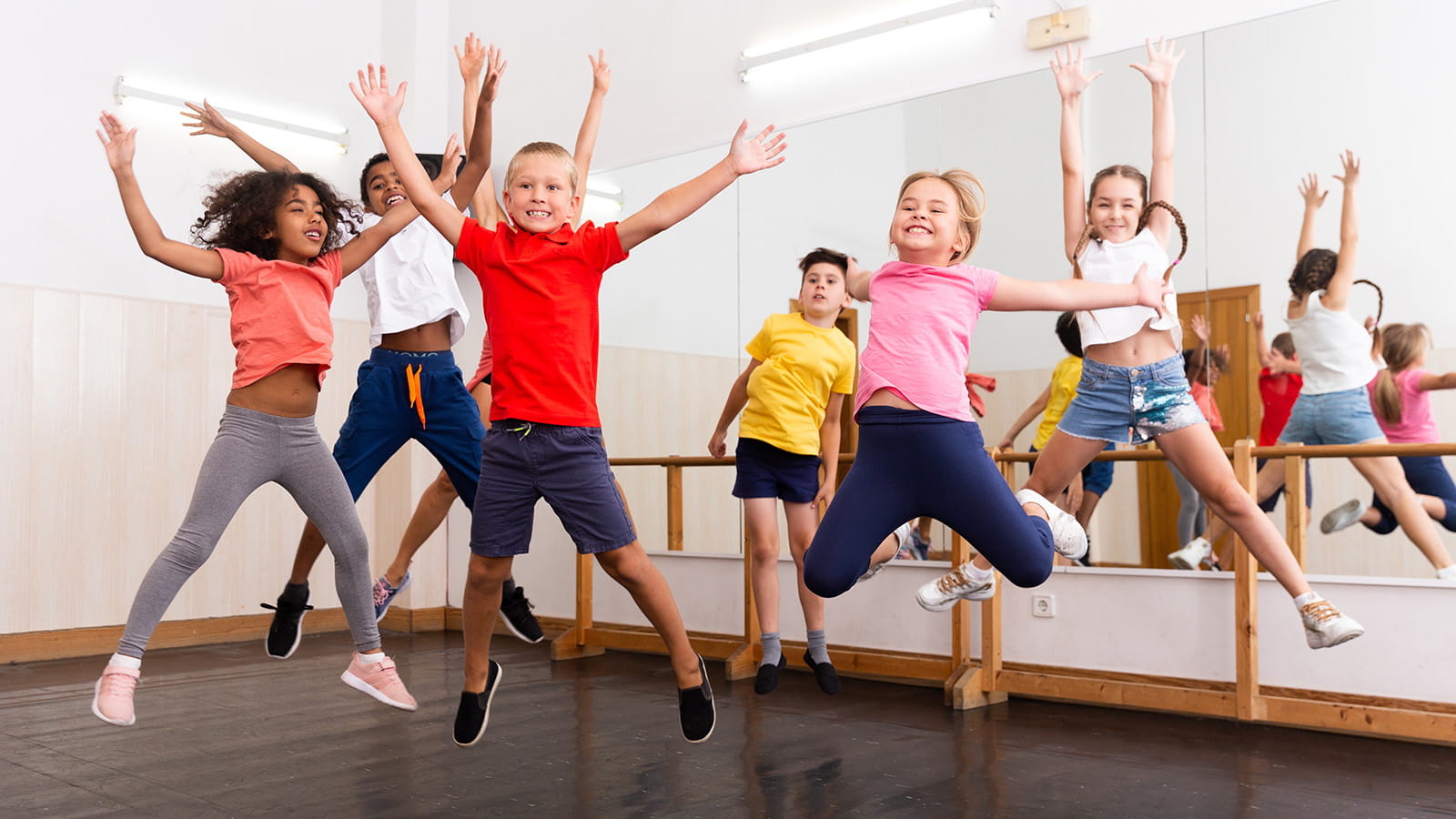 Children jumping in the air in a dance studio